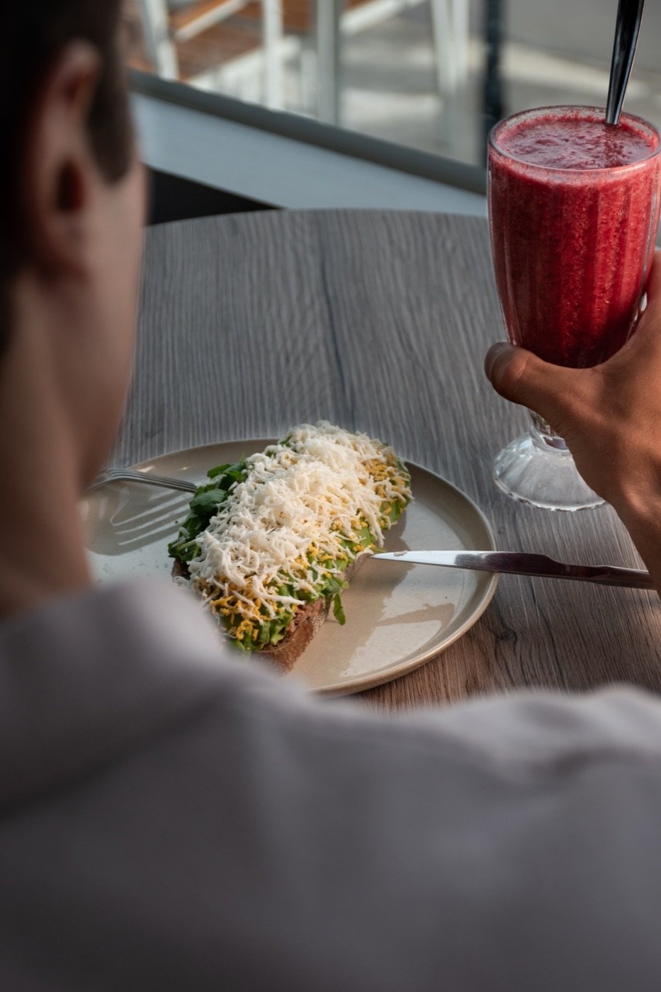 Cliente con batido de frutos rojos y tostada
